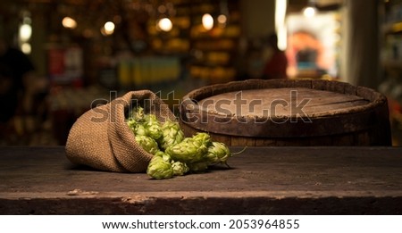 Hop twig over old wooden table background. Vintage style. Beer production ingredient. Brewery. Fresh-picked whole hops close-up. Brewing concept wallpaper. Royalty-Free Stock Photo #2053964855