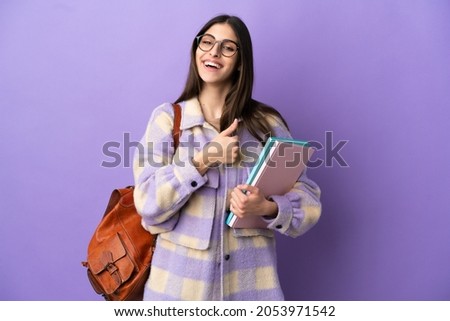 Young student woman isolated on purple background giving a thumbs up gesture Royalty-Free Stock Photo #2053971542