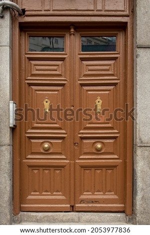 Old wooden entrance door to a stone building painted in brown color
