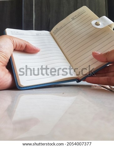 This is a photo of a hand holding a notebook