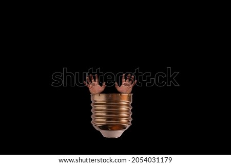 Creative concept - come to light.
Bulb thread with two human hands on a dark background.