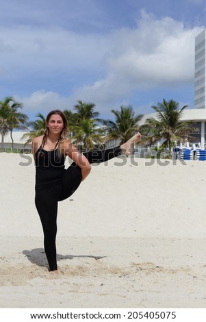 Stock image of woman in a balancing yoga pose on the beach