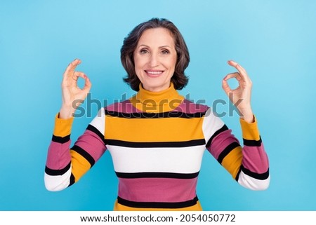 Photo of cool white hairdo old lady show okey wear striped pullover isolated on blue color background