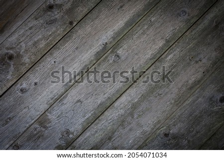 Wooden logs of an old house. Close-up. Weathered natural gray wood texture. Background. Horizontal photo.