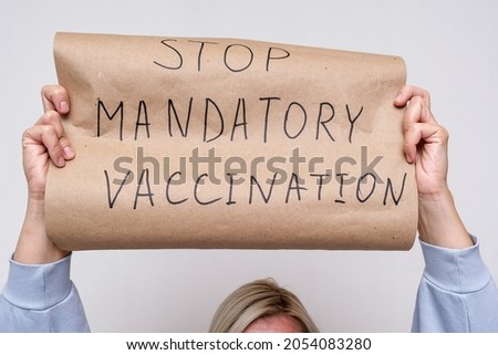 An unrecognizable woman holding a poster, sign No mandatory vaccination, she expresses a protest against forced vaccines, vaccination.