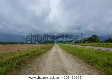 dramatic storm cloud coming before heavy rain on Paddy field