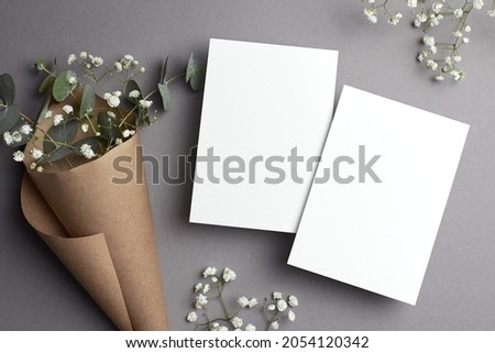 Wedding invitation card mockup with copy space, front and back sides, natural eucalyptus and gypsophila flowers decorations.