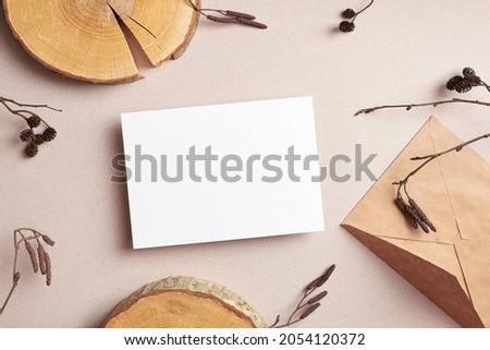 Invitation or greeting card mockup with craft envelope and dry tree twigs decorations