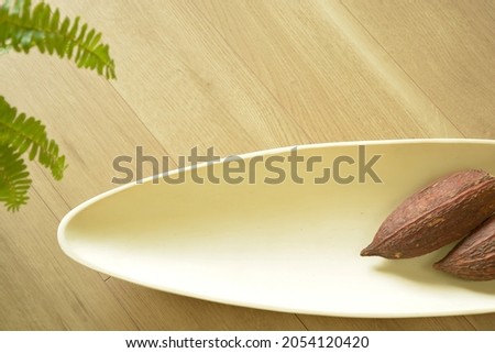 Top view photo of  White bowl.  with Cacao pod. 

white sign board with copy space. 
blurred background soft focus image.
