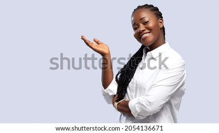African American woman pointing both hands on upper side with smiling face. Smiling beautiful professional business African American black woman showing empty copy space on white background Royalty-Free Stock Photo #2054136671