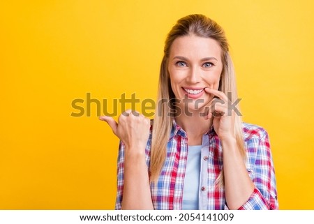 Photo of nice blond young lady point empty space wear plaid shirt isolated on yellow color background