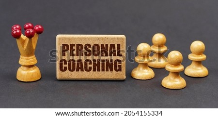 Business concept. On a black background, chess and a sign with the inscription - PERSONAL COACHING