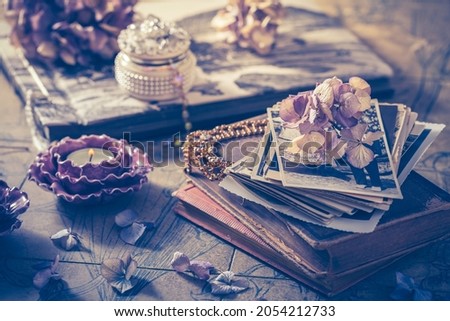 Memories - old family photo album with necklace, old books and dried flowers and candles