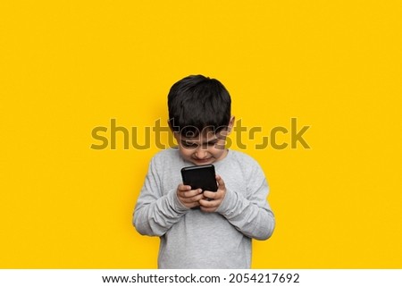 leisure, children, technology and people concept - smiling boy with smartphone  or playing game at home copy space