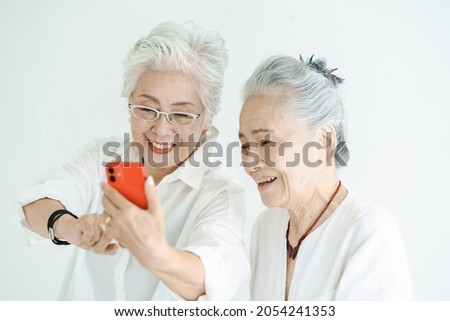 Senior women looking at smartphone screens with a smile