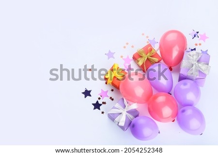 Gift boxes and air balloons on light background