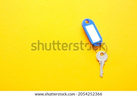 Plastic tag with key on color background