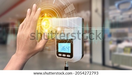 Hand show up of The entrance door with Digital thermometer temperature scanning machine before walk in the store in situations disease COVID-19 virus. Royalty-Free Stock Photo #2054272793
