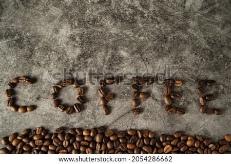 Flat lay of a group of beans of coffee making letters of coffee word in a surface with coffee beans