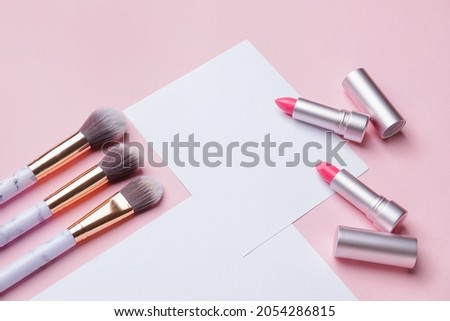 Composition with blank cards and makeup cosmetics on color background