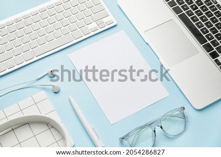 Composition with blank card, computers and stationery on color background