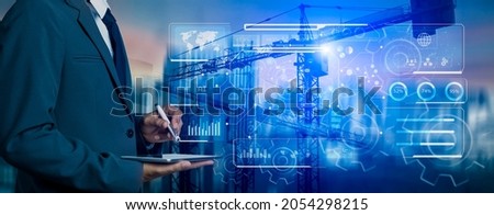 Double exposure of businessman hands using tablet and technology global networking security information with innovation icon virtual screen, Digital and construction cranes on city blurred background.