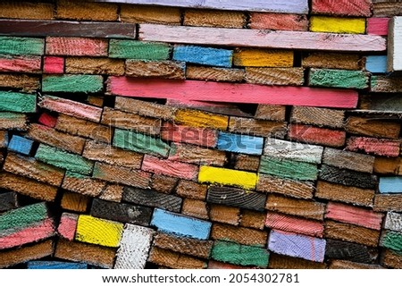 closeup front view of stacked wooden planks decorated with paint in different colors