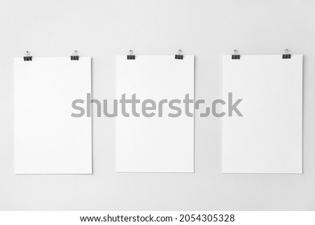 Blank posters hanging on white wall