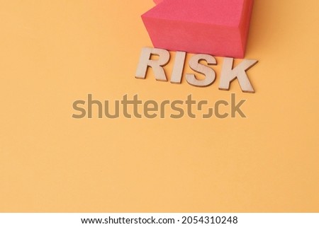 RISK phrase using colorful cubes on the wooden blocks. Noise is visible due to the texture of the subjects 