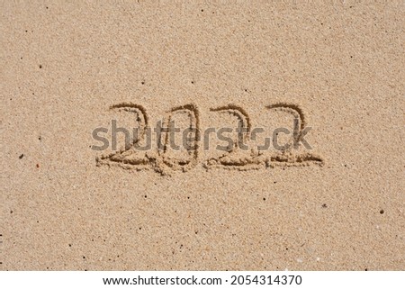 2022 written on the beach sand.