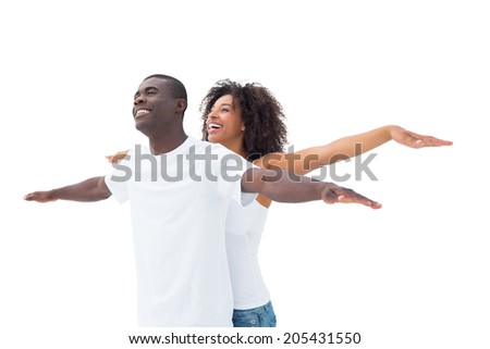 Casual couple standing with arms outstretched on white background