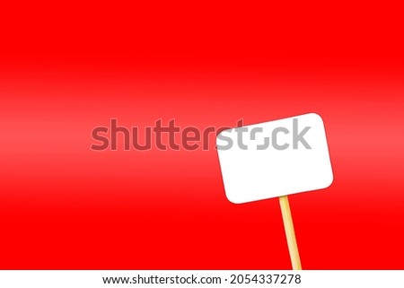 white tag on a wooden leg on a red background