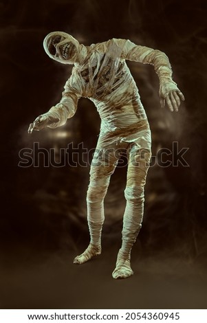Scary and sinister mummy wandering in a dark tomb. Full length studio portrait with dark background. Ancient Egyptian mythology. Halloween. 