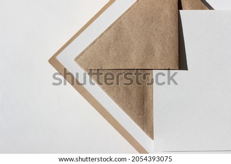 Home Office Desk Closeup. White Blank Paper Sheet on Brown Envelope. 