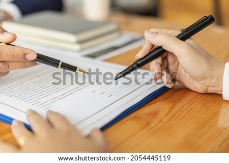 The manager points to the employment contract for the applicant to sign as an agreement to work, the applicant signs the contract to work with the company, the salary agreement and benefits.