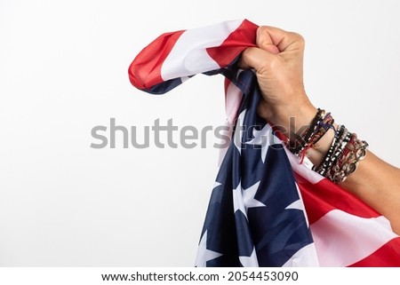 
Woman's hand tightly holds the America flag. On white background