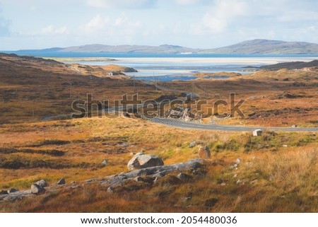 Empty, winding road towards the white sands of Seilebost Beach on the Isle of Lewis and Harris in the Outer Hebrides of Scotland. Royalty-Free Stock Photo #2054480036