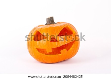 Orange pumpkin carved into creepy and funny Jack o Lantern isolated on white background. All hallows night. Copy space, close up, top view. Halloween party decoration. Trick or treat concept.