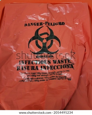 Red Biohazard waste bag with black biohazard warning symbol in hospital setting