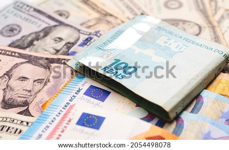 Real (BRL), US dollar and Euro. A brazilian banknote of 100 reais on dollar bills. Exchange concepts, international investments and the Brazilian economy.
 Royalty-Free Stock Photo #2054498078