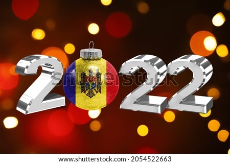 Colorful blurred background and applied the flag of Moldova on the New Year's toy. New Year 2022 Celebration