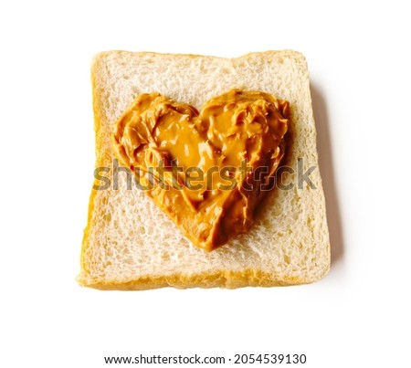 A heart-shaped piece of peanut butter spread in the center of the bread on white background. Isolated. Royalty-Free Stock Photo #2054539130