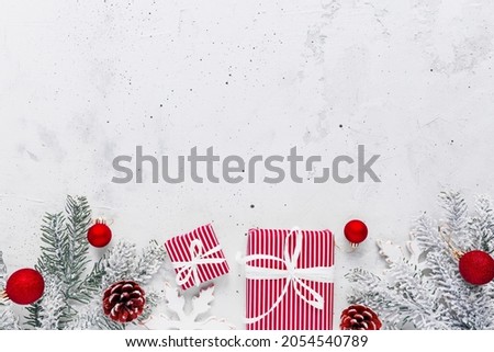 Christmas, New Year gray concrete flat lay with red white present gift boxes top view. Gift ribbon and packaging paper. Christmas tree fir, cones, toys. Copy space text area on high quality photo