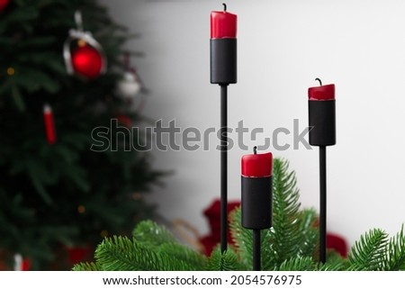 Red candles on a white background. Cozy Christmas interior. High quality photo