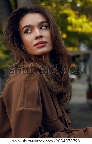 Photo of a beautiful brunette girl in stylish clothes in the city