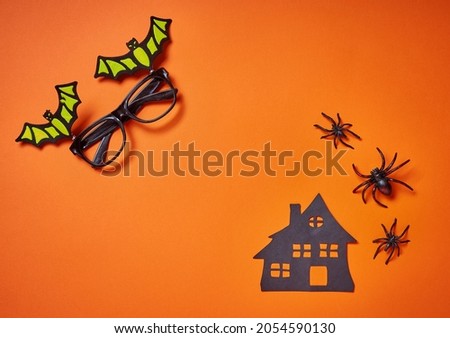 Happy Halloween banner orange background with spiders, house and bat funny glasses. Place for text. Design for Web ads promo sales, social media fall offer, trick or treat, invitation, free space