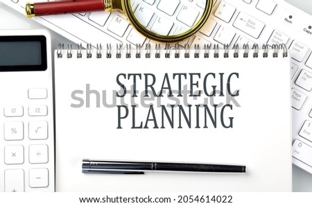 STRATEGIC PLANNING . Text on notepad with calculator and keyboard,business