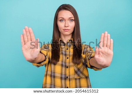 Portrait of focused concentrated pretty girl hands palms show no gesture isolated on blue color background