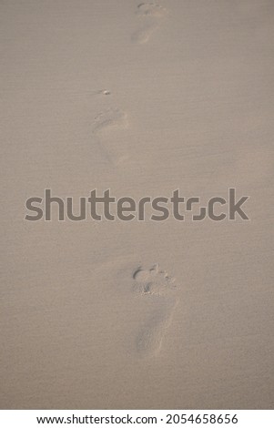 Footprints in the fine and soft sand at Hua Hin Beach, Thailand, walking without shoes on the sand is relaxing, comfortable, makes you feel good. It is one of the best relaxation for the body.