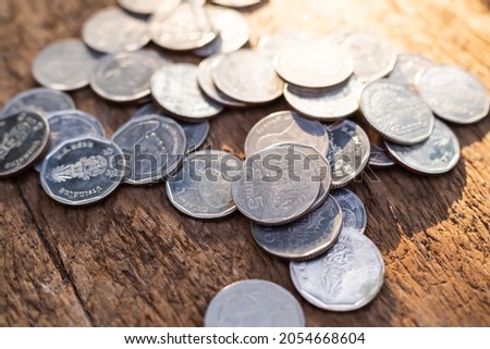 Thai coin 5 baht on wood background. plan saving and investment money for 2022 new year. stack cash with overlight day. business and finance concept.
